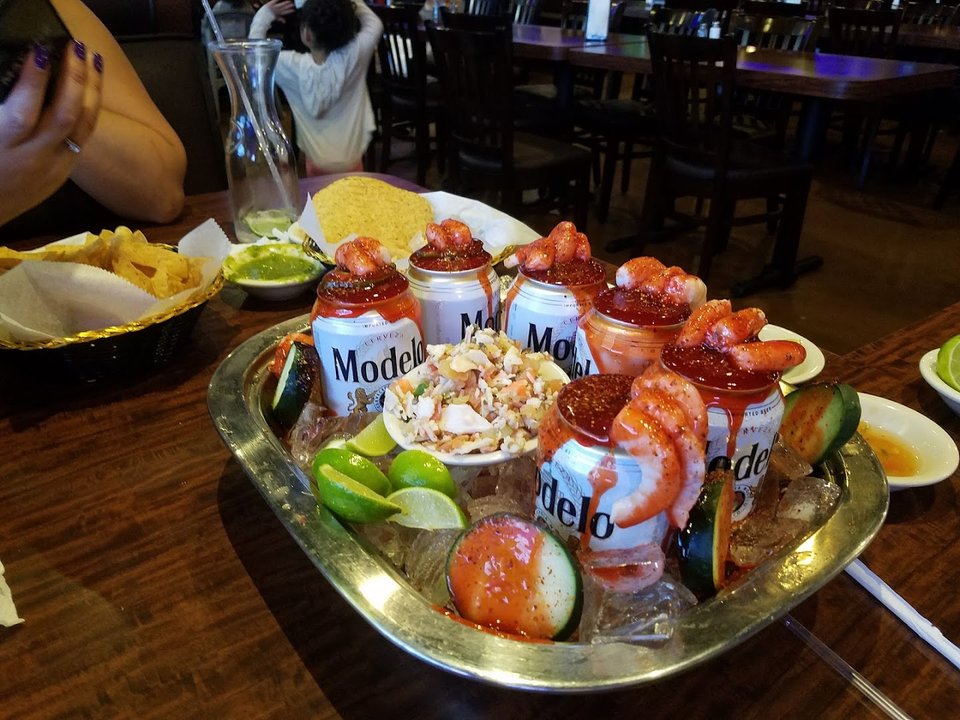Plates of comfort food beside drinks.